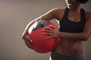 mulher negra carregando bola de crossfit foto