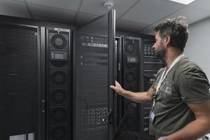 engenheiro de data center usando teclado em uma instalação especializada em sala de servidores de supercomputador com administrador de sistema masculino foto