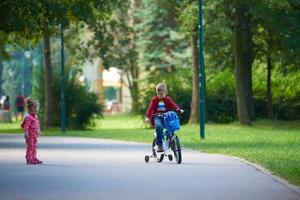 menino e menina com bicicleta foto