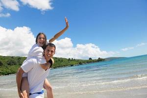 casal feliz se diverte na praia foto