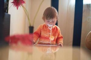 bebê brincando com tablet em casa foto