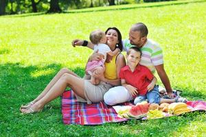 casal jovem feliz com seus filhos se divertir no parque foto