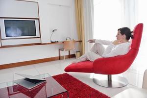 mulher jovem feliz relaxa em casa no sofá foto