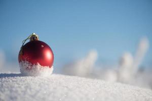 bola vermelha de natal na neve fresca foto