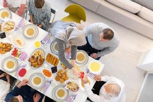 vista superior da família muçulmana multiétnica moderna tendo um banquete do ramadã foto