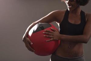 mulher negra carregando bola de crossfit foto