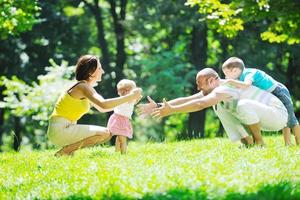 casal jovem feliz com seus filhos se divertir no parque foto