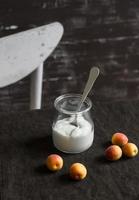 iogurte natural em uma jarra de vidro e um damasco fresco foto