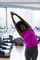 mulher afro-americana exercita ioga no ginásio