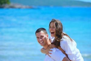 casal feliz se diverte na praia foto