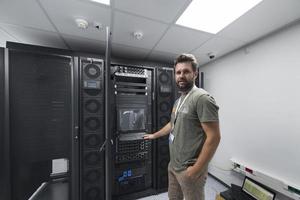 engenheiro de data center usando teclado em uma instalação especializada em sala de servidores de supercomputador com administrador de sistema masculino foto