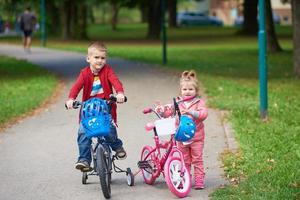 menino e menina com bicicleta foto