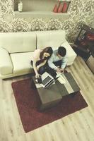 jovem casal trabalhando no laptop em casa foto