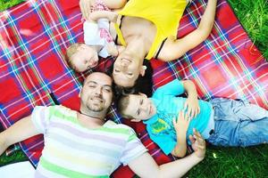 casal jovem feliz com seus filhos se divertir no parque foto