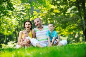 casal jovem feliz com seus filhos se divertir no parque foto