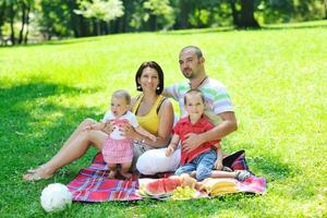 casal jovem feliz com seus filhos se divertir no parque foto