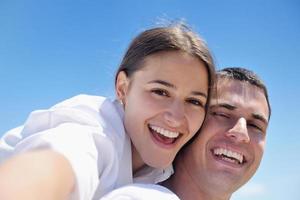 casal feliz se diverte na praia foto