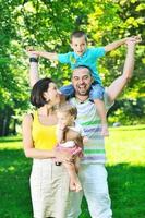 casal jovem feliz com seus filhos se divertir no parque foto