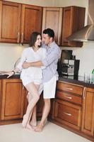 feliz casal jovem se diverte na cozinha moderna foto
