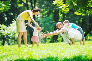 casal jovem feliz com seus filhos se divertir no parque foto