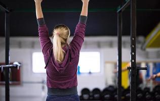 mulher fazendo pull ups na barra horizontal foto