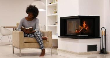 mulher negra em casa lendo livro foto