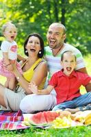 casal jovem feliz com seus filhos se divertir no parque foto