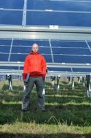 engenheiro usando laptop no campo de planta de painéis solares foto