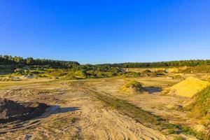 montanhas de areia escavadas e pilhas de entulho pedreira lago dragagem lagoa. foto