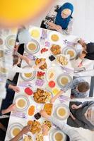 vista superior da família muçulmana multiétnica moderna tendo um banquete do ramadã foto