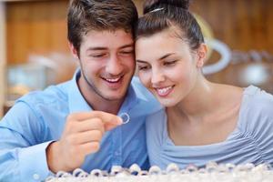 casal jovem feliz em joalheria foto