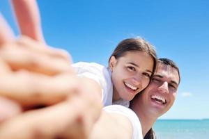 casal feliz se diverte na praia foto