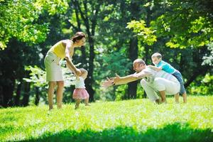 casal jovem feliz com seus filhos se divertir no parque foto