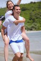 casal feliz se diverte na praia foto