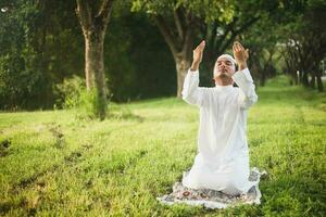 homem muçulmano rezando ao ar livre. natureza landscape.muslim homem rezando na oração verde meadow.muslim, a luz da fé, esperança, fé. homem muçulmano rezando para Deus Deus do Islã no prado verde. foto