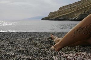 esticando as pernas e os pés na praia em creta foto