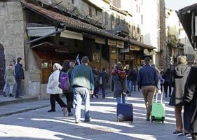 florença, itália, 2019 - turistas cruzando a famosa ponte ponte vecchio com seus carrinhos em florença, itália. foto