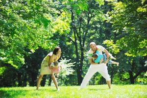 casal jovem feliz com seus filhos se divertir no parque foto