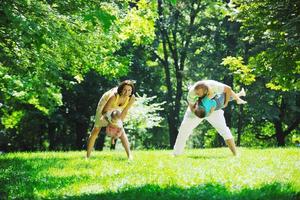 casal jovem feliz com seus filhos se divertir no parque foto