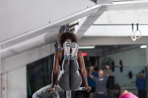 mulher negra fazendo exercício de barras paralelas foto