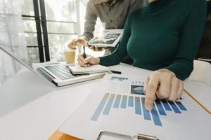 empresários reunidos para analisar e discutir e debater os dados do gráfico do relatório financeiro no trabalho em equipe do consultor financeiro do escritório e no conceito de contabilidade. foto