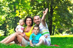 casal jovem feliz com seus filhos se divertir no parque foto