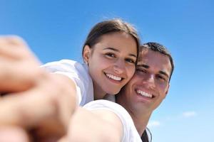 feliz casal jovem se divertir na praia foto