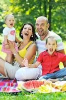 casal jovem feliz com seus filhos se divertir no parque foto