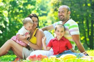 casal jovem feliz com seus filhos se divertir no parque foto