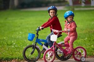 menino e menina com bicicleta foto