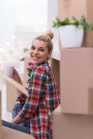 mulher com muitas caixas de papelão sentadas no chão foto