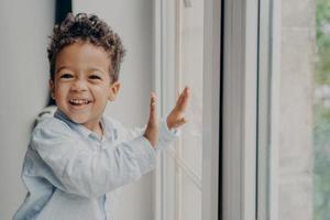 retrato de criança negra alegre com sorriso adorável se divertindo em casa foto