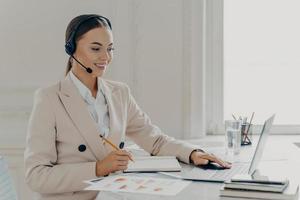 operador de call center usando fone de ouvido conversando com cliente foto