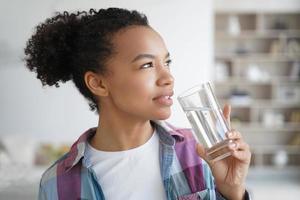 linda jovem hispânica desfrutando de água mineral. estilo de vida saudável, fitness e bem-estar. foto